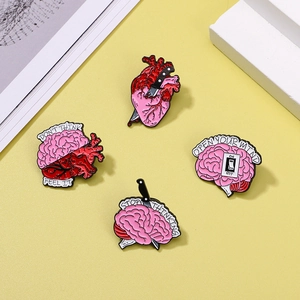 Set of 4 creative heart and brain enamel pins with anatomic designs on yellow background