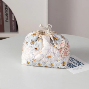 Close-up of floral quilted cosmetic bag with drawstring and菱格 diamond texture details