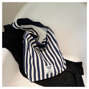 Detailed top view of blue and white striped canvas bag with minimalist woven logo tag