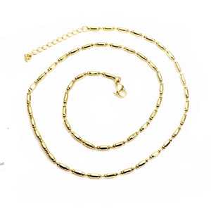 Polished gold beaded necklace with adjustable extender chain on a clean white background