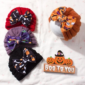 Halloween infant knit hat with large festive bow featuring pumpkin and ghost patterns