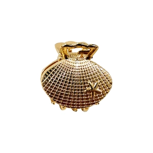 Golden shell-shaped hair claw with starfish detail on a minimalist white background