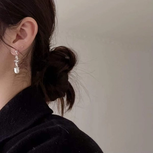 Close-up of elegant 925 silver irregular pearl drop earrings worn by a model