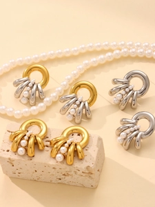 Detail of fan-shaped multi-layered pearl earrings in gold and silver finish