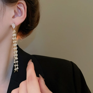 Close-up of 18k gold plated long tassel earrings with sparkling zircon crystals on model