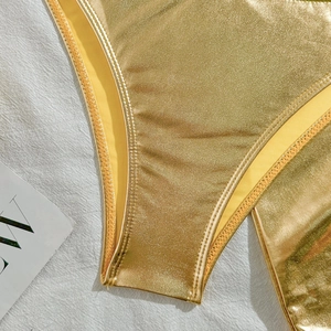 Detailed close-up of metallic gold bikini bottoms featuring professional twin-needle stitching