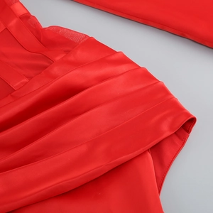Close-up of red satin dress fabric with mesh splicing and elegant pleated details