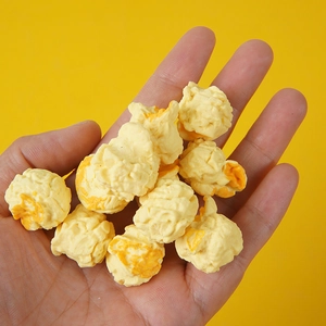 Realistic PVC popcorn model set in palm for scale with creamy and caramel textures