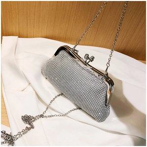 Detail of silver rhinestone clutch with metal frame and sparkling diamond chain strap