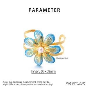 Detailed view of gold plated stainless steel flower bangle with blue enamel and pearl inlay