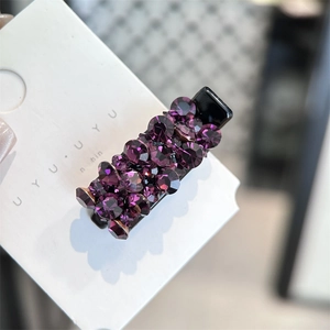 Détail de la barrette à cheveux en strass violets sur un clip bec de canard noir mat
