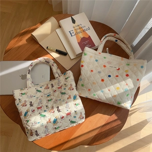Quilted cotton tote bags with colorful dog patterns and dots on a wooden table