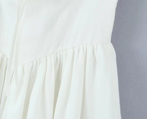 Detailed macro shot of white dress fabric texture with intricate pleated stitching