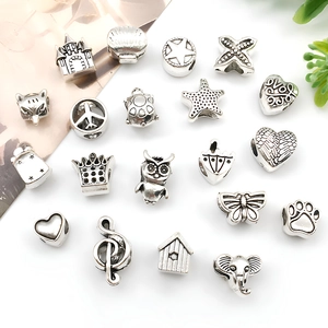 Macro detail of 20 assorted silver alloy charms featuring star, shell, and heart designs