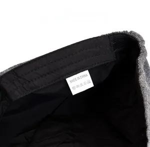 Detailed macro view of gray newsboy hat inner lining with care label and washing symbols