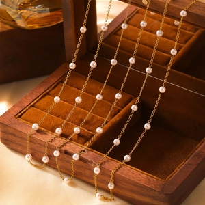 Elegant gold titanium necklace with minimalist pearl beads in a luxury wooden gift box