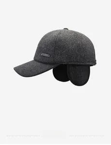 Detail view of dark grey winter hat with ear flaps and SPORT metal logo badge