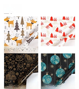 Detail of four Christmas kraft wrapping paper rolls with deer and snowflake patterns