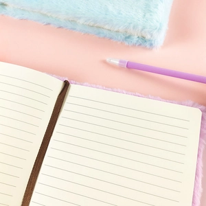 Detail of plush notebook set with purple faux fur cover, lined pages and a matching pen