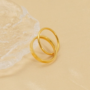 Detail of elegant gold double-layered titanium rings on warm textured fabric background