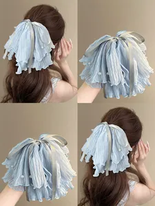 Detail of light blue pleated mesh hair claw with white pearls and satin ribbon bow decoration