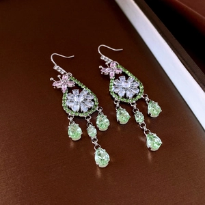 Vue détaillée de boucles d'oreilles argentées avec fleurs en zircon rose et pendentifs verts