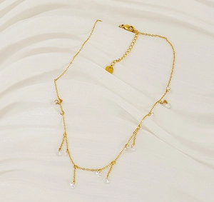 Detail of gold crystal tassel necklace showing delicate chain and zircon drop pendants