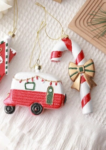 Detail of resin Christmas candy cane and vintage camper ornaments with festive decorations