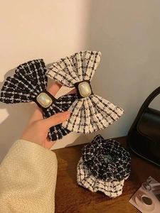 Detail of black and white tweed hair bows and scrunchies with elegant pearl embellishments
