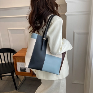 Große Colorblock-Tote-Bag mit Schnallenriemen, getragen von Model im weißen Blazer