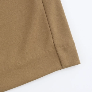 Macro shot of brown knitted fabric texture showing pleated details and material quality