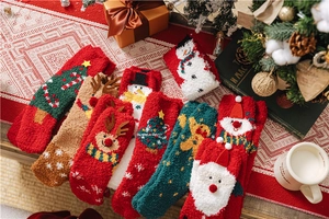Detailed view of plush coral fleece Christmas socks in various festive patterns and colors