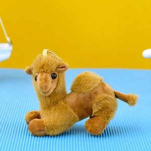 Close-up shot of a small plush camel keychain pendant with soft brown fur texture