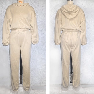 Detail view of beige tracksuit featuring hooded sweatshirt and high-waisted joggers set