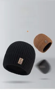 Detailed knit texture and leather brand patch on black and brown thermal winter beanies