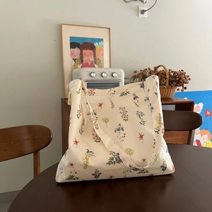 Chic beige floral canvas tote bag with floral print on a rustic wooden table setting