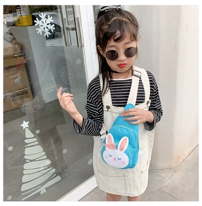 Blue kids crossbody bag with white rabbit face and pink sequins worn by young girl model