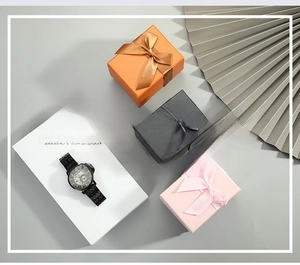 Detailed view of skeleton mechanical watch displayed with ribbon bow gift boxes