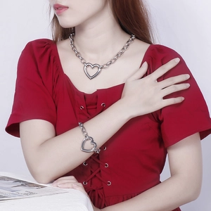 Detail of silver chunky chain necklace and bracelet set with hollow heart pendants