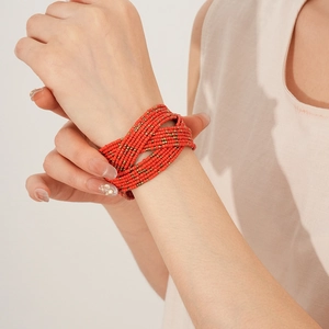 Détail d'un bracelet multicouche en perles de verre rouge et orange doré