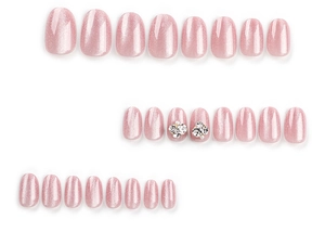 Detail view of pink cat-eye press-on nails with rhinestone accents and glitter finish