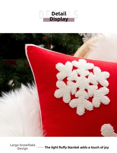 Detail of red Christmas pillowcase showing white tufted snowflake embroidery and fabric texture