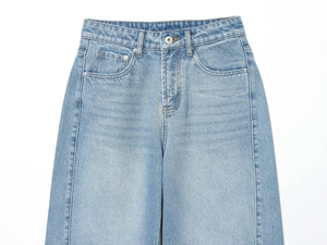 Dettaglio di jeans a vita alta con chiusura a bottone in metallo e cuciture classiche