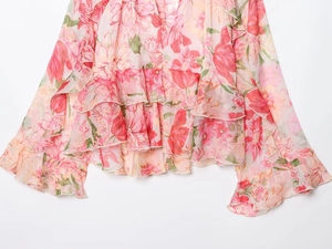 Dettaglio di tessuto in chiffon floreale rosa con design a balze e strati delicati