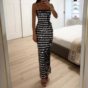Close-up of sparkling silver sequins on a slim fit black maxi dress with thin straps