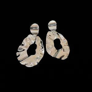 Irregular silver earrings with abstract hammered texture and geometric hollow design