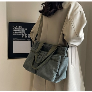 Detail of grey-green corduroy tote bag showing multiple pockets and soft texture material