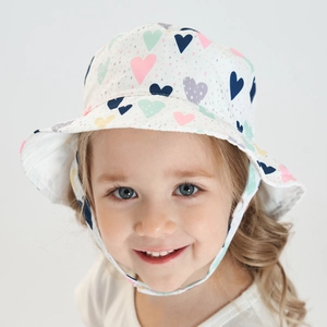 Détail d'un chapeau de soleil enfant avec motifs de cœurs et mentonnière ajustable