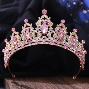 Close-up of golden bridal crown featuring pink teardrop crystals and intricate rhinestones