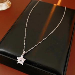 Vue macro d'un pendentif étoile en zircon sur une chaîne en argent et boîte en cuir